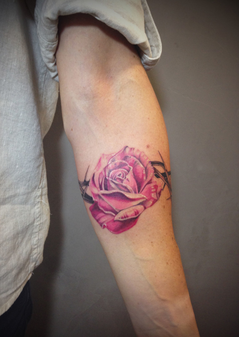 Tatto of a pink rose with spines