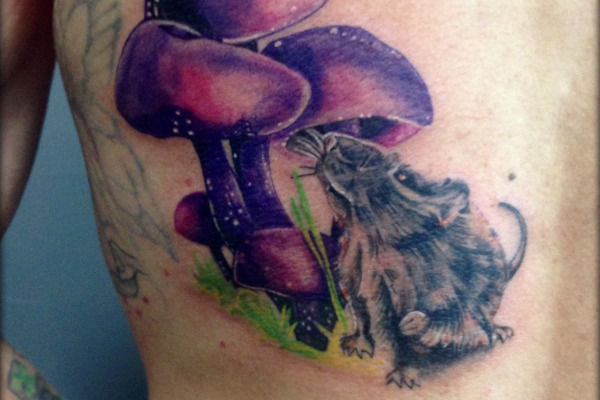 Tatouage realiste d'une souris sous un champignon